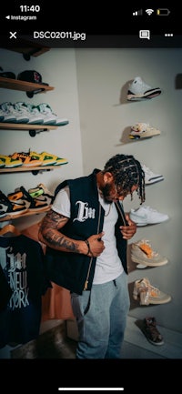 a man is standing in front of a shelf full of shoes